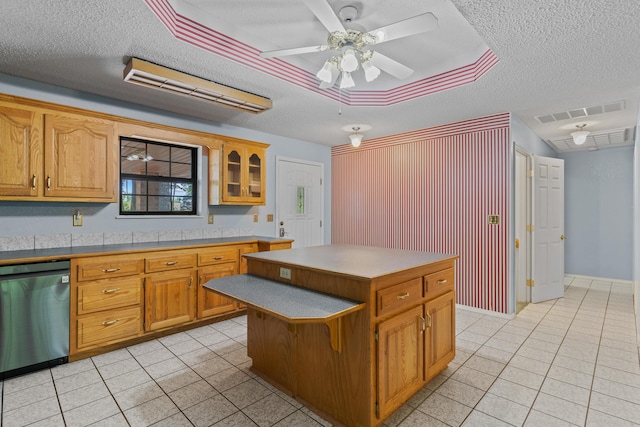 8756 W Farm Rd Unit 124, Springfield, MO 65802 - kitchen with stainless steel dishwasher, a textured ceiling, light tile patterned flooring, a ceiling fan, and a kitchen island
