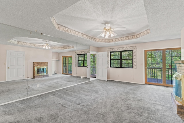 8756 W Farm Rd Unit 124, Springfield, MO 65802 - unfurnished living room with ceiling fan, a raised ceiling, a textured ceiling, and a fireplace