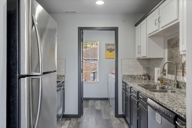 2915 Vineyards Pkwy Unit 6, Branson, MO 65616 - kitchen with stainless steel appliances, light wood-style flooring, tasteful backsplash, white cabinetry, and light stone counters
