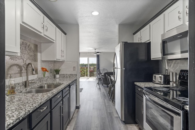 2915 Vineyards Pkwy Unit 6, Branson, MO 65616 - kitchen with stainless steel appliances, ceiling fan, a textured ceiling, light wood-type flooring, and backsplash
