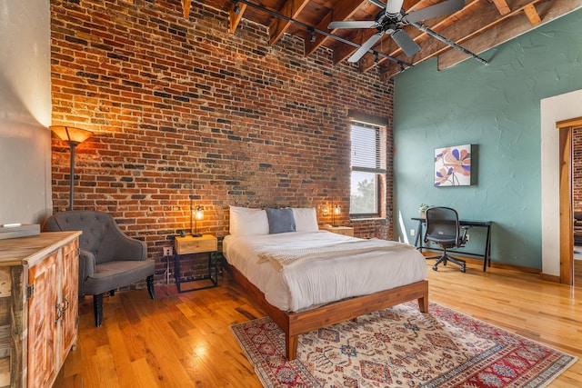 509 W Olive St Unit 206, Springfield, MO 65806 - bedroom featuring brick wall, hardwood / wood-style floors, a wooden ceiling with exposed beams, a high ceiling, and ceiling fan