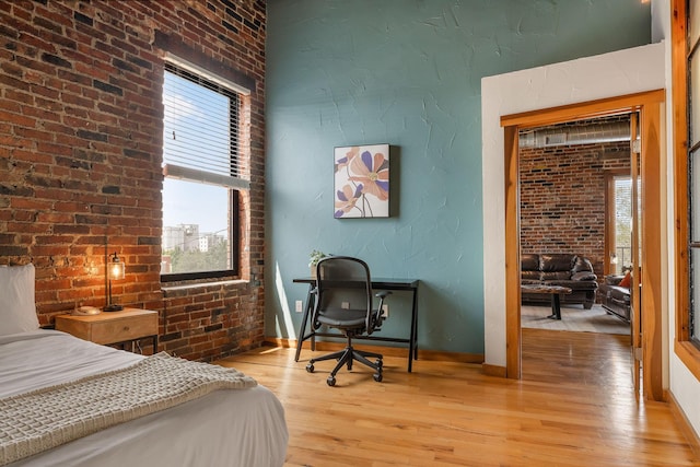 509 W Olive St Unit 206, Springfield, MO 65806 - bedroom featuring light wood-type flooring and brick wall