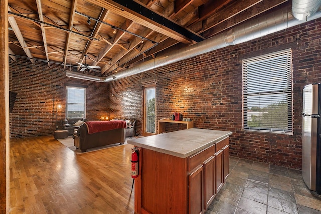 509 W Olive St Unit 206, Springfield, MO 65806 - kitchen featuring brick wall, freestanding refrigerator, open floor plan, a wooden ceiling with exposed beams, and ceiling fan