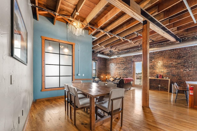 509 W Olive St Unit 206, Springfield, MO 65806 - dining space featuring wood-type flooring, brick wall, and a wood ceiling with exposed beams