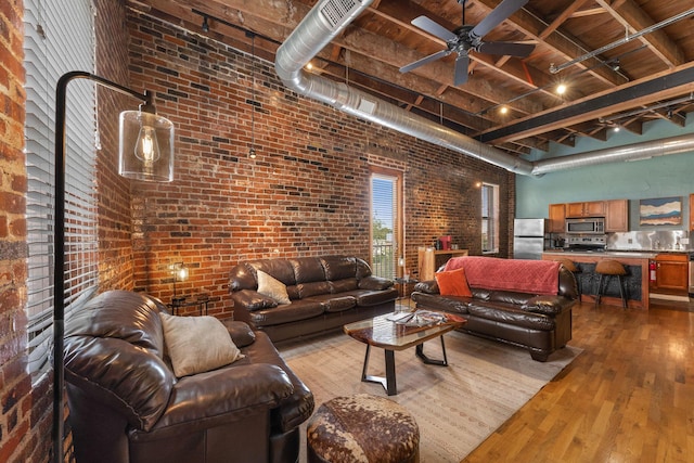 509 W Olive St Unit 206, Springfield, MO 65806 - living room with brick wall, wood-type flooring, a high ceiling, and ceiling fan