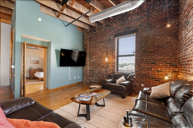 509 W Olive St Unit 206, Springfield, MO 65806 - living area featuring brick wall, wood finished floors, a towering ceiling, and beam ceiling