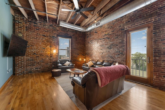 509 W Olive St Unit 206, Springfield, MO 65806 - living room featuring brick wall, a wood ceiling with exposed beams, wood finished floors, a ceiling fan, and a high ceiling
