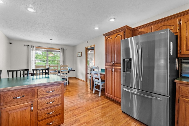 2602 S 15th Ave, Ozark, MO 65721 - kitchen featuring stainless steel fridge with ice dispenser, light wood finished floors, brown cabinets, a textured ceiling, and dark countertops