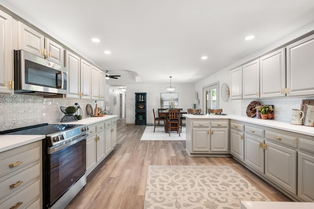 620 E Summit St, Bolivar, MO 65613 - kitchen with appliances with stainless steel finishes, light wood-style floors, ceiling fan, decorative backsplash, and recessed lighting