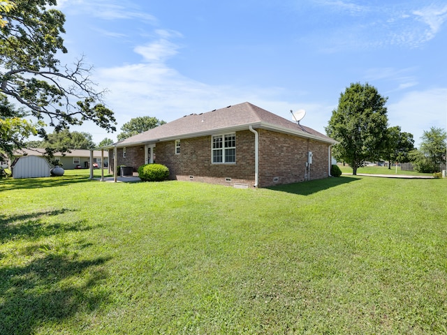 620 E Summit St, Bolivar, MO 65613 - rear view of house featuring crawl space, brick siding, a yard, and a storage shed
