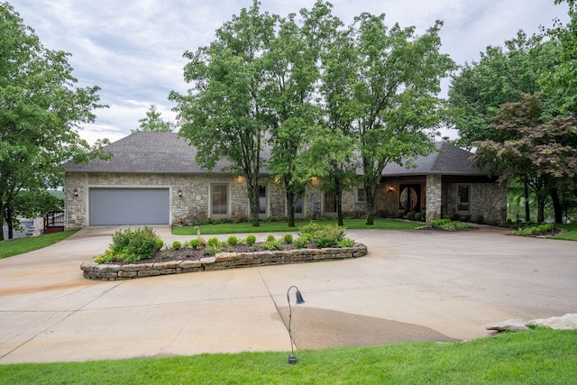 10 Patterson Ave, Branson, MO 65616 - view of front of home with stone siding, concrete driveway, a garage, and roof with shingles