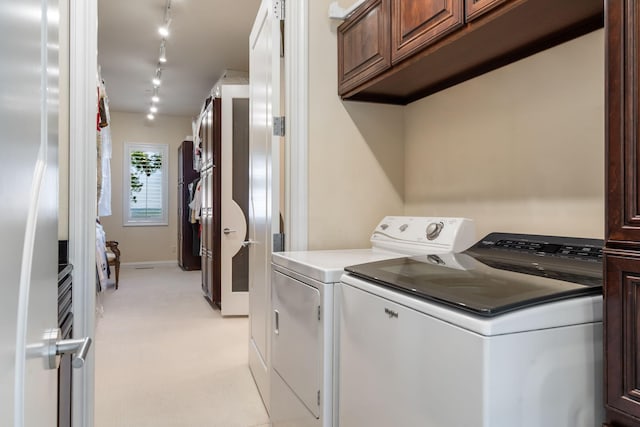 10 Patterson Ave, Branson, MO 65616 - washroom featuring washer and clothes dryer, cabinet space, light carpet, and rail lighting