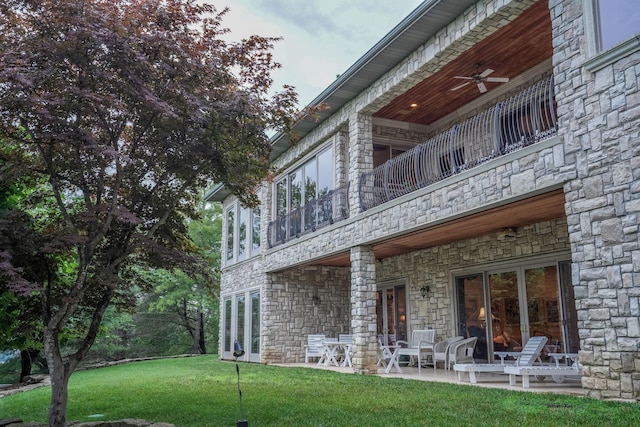 10 Patterson Ave, Branson, MO 65616 - back of house featuring stone siding, a balcony, a ceiling fan, a yard, and a patio