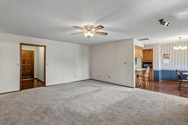 2812 E Linwood St, Springfield, MO 65804 - unfurnished living room with carpet flooring, wallpapered walls, a ceiling fan, a chandelier, and a textured ceiling
