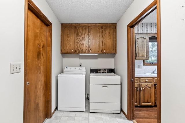 2812 E Linwood St, Springfield, MO 65804 - laundry area featuring washing machine and clothes dryer, cabinet space, and a textured ceiling