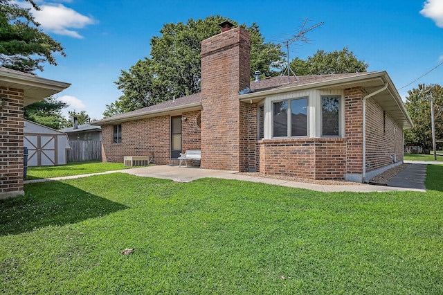 2812 E Linwood St, Springfield, MO 65804 - rear view of house with brick siding, a yard, a chimney, and a patio