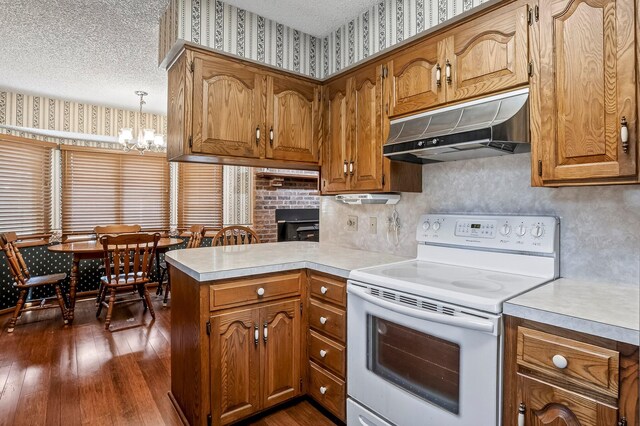 2812 E Linwood St, Springfield, MO 65804 - kitchen featuring electric stove, under cabinet range hood, dark wood finished floors, a peninsula, and brown cabinetry