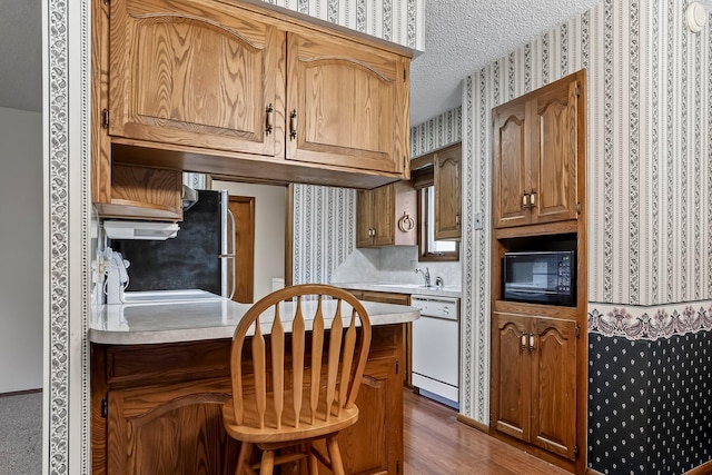 2812 E Linwood St, Springfield, MO 65804 - kitchen with dishwasher, black microwave, wallpapered walls, light countertops, and a textured ceiling