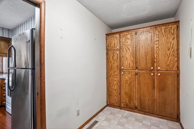2812 E Linwood St, Springfield, MO 65804 - kitchen with freestanding refrigerator, a textured ceiling, brown cabinetry, and stove