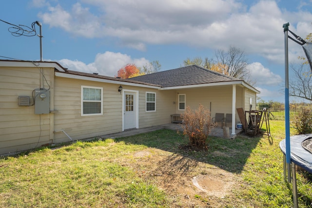 3197 S Grand Ave, Carthage, MO 64836 - rear view of property featuring a yard, a patio, a trampoline, and a shingled roof