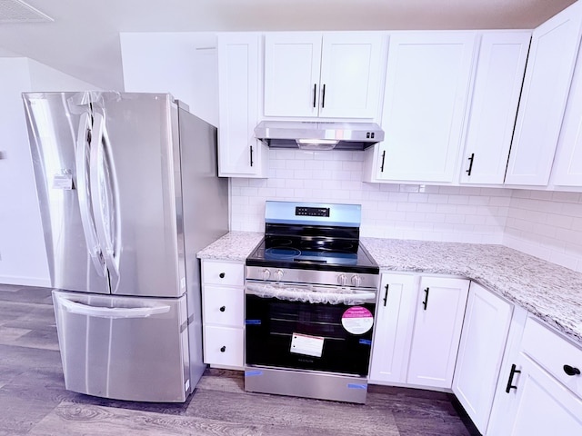 401 E 17th St, Lockwood, MO 65682 - kitchen with stainless steel appliances, under cabinet range hood, wood finished floors, and white cabinets