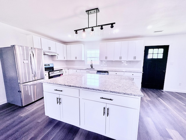 401 E 17th St, Lockwood, MO 65682 - kitchen featuring appliances with stainless steel finishes, under cabinet range hood, dark wood-style flooring, and a center island