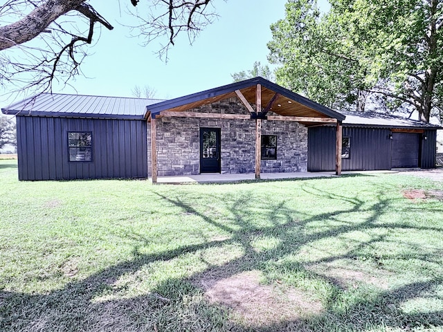 401 E 17th St, Lockwood, MO 65682 - rear view of property with board and batten siding, a yard, an attached garage, and ceiling fan