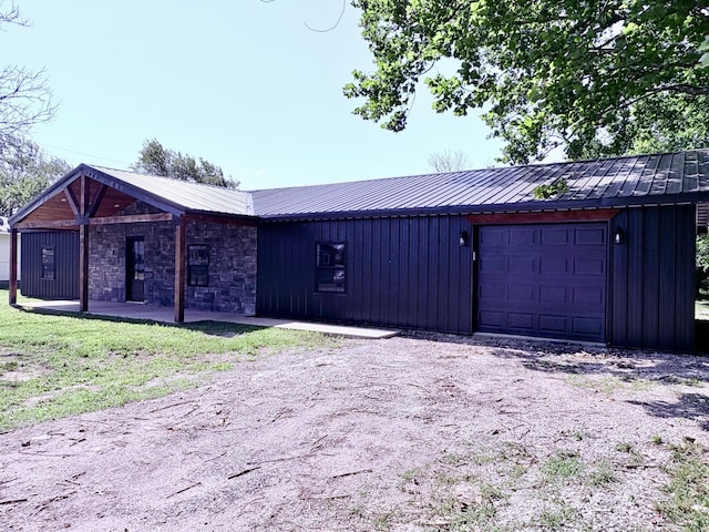 401 E 17th St, Lockwood, MO 65682 - view of front of home with a garage, board and batten siding, dirt driveway, and a metal roof