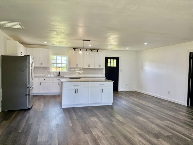 401 E 17th St, Lockwood, MO 65682 - kitchen with freestanding refrigerator, dark wood-style floors, tasteful backsplash, a center island, and recessed lighting