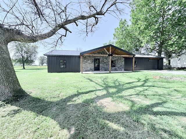 401 E 17th St, Lockwood, MO 65682 - rear view of house with a yard, an attached garage, and a metal roof