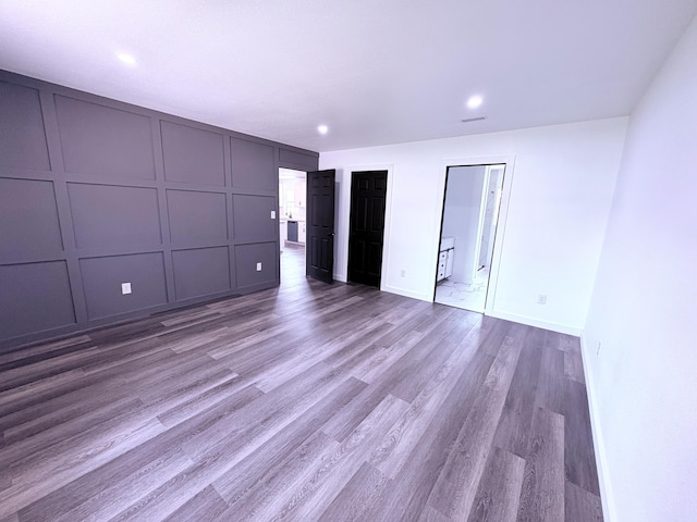 401 E 17th St, Lockwood, MO 65682 - unfurnished bedroom with a decorative wall, wood finished floors, and recessed lighting
