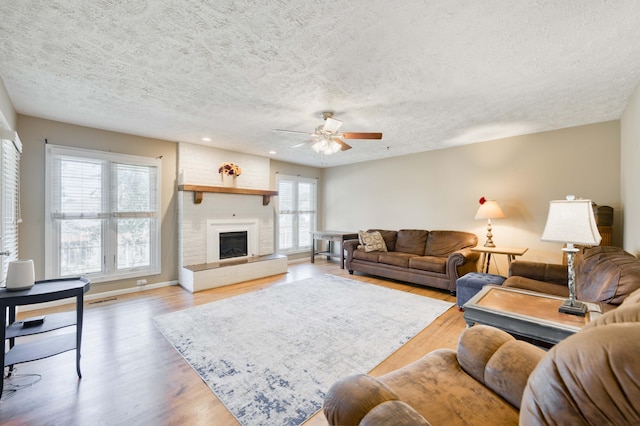 3477 W Broadmoor Ct, Springfield, MO 65807 - living room with a textured ceiling, a ceiling fan, wood finished floors, a large fireplace, and recessed lighting