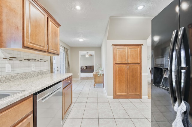 3477 W Broadmoor Ct, Springfield, MO 65807 - kitchen with black fridge, stainless steel dishwasher, light countertops, decorative backsplash, and a textured ceiling