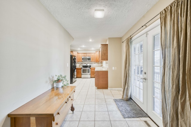 3477 W Broadmoor Ct, Springfield, MO 65807 - kitchen with appliances with stainless steel finishes, light tile patterned floors, french doors, light countertops, and a textured ceiling