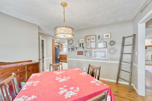 3477 W Broadmoor Ct, Springfield, MO 65807 - dining room with light wood-type flooring and a textured ceiling