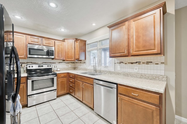 3477 W Broadmoor Ct, Springfield, MO 65807 - kitchen featuring stainless steel appliances, decorative backsplash, recessed lighting, light tile patterned floors, and brown cabinetry