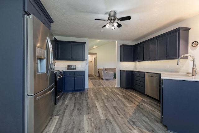 360 Durango Ln, Billings, MO 65610 - kitchen with appliances with stainless steel finishes, ceiling fan, wood finished floors, light countertops, and blue cabinets