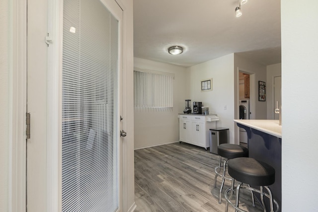 360 Durango Ln, Billings, MO 65610 - kitchen with light wood-type flooring, light countertops, white cabinetry, washer / clothes dryer, and a kitchen breakfast bar