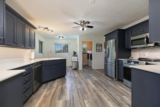 360 Durango Ln, Billings, MO 65610 - kitchen with washing machine and clothes dryer, stainless steel appliances, light wood-style floors, a ceiling fan, and light countertops