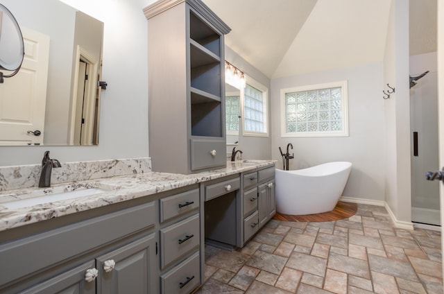 4225 E Crosswinds Pl, Springfield, MO 65809 - full bath featuring double vanity, a freestanding tub, stone finish floors, and lofted ceiling