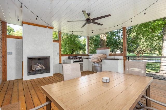 4225 E Crosswinds Pl, Springfield, MO 65809 - wooden deck featuring exterior fireplace, exterior kitchen, outdoor dining area, and ceiling fan