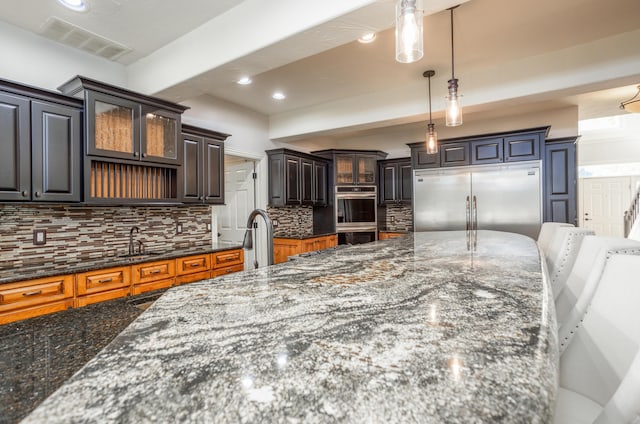 4225 E Crosswinds Pl, Springfield, MO 65809 - kitchen with stainless steel appliances, decorative backsplash, glass insert cabinets, dark stone countertops, and recessed lighting