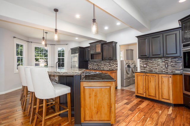 4225 E Crosswinds Pl, Springfield, MO 65809 - kitchen featuring wood finished floors, washer and clothes dryer, decorative backsplash, recessed lighting, and beam ceiling