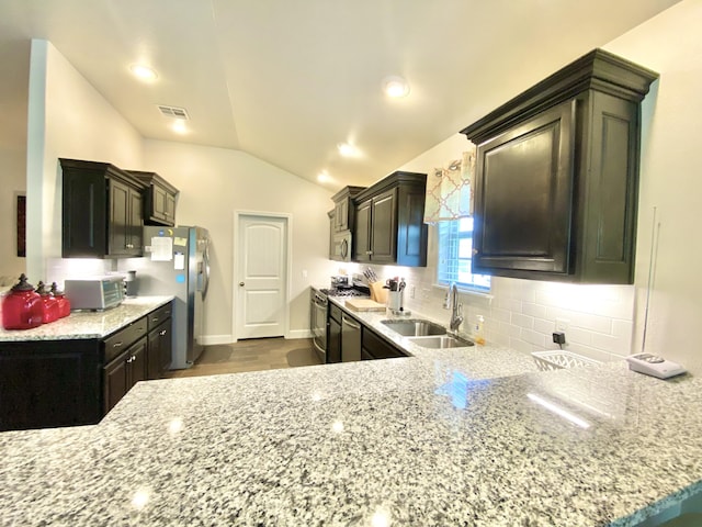 1113 Chesterfield Dr, Webb City, MO 64870 - kitchen featuring stainless steel appliances, lofted ceiling, tasteful backsplash, light stone counters, and dark wood-style floors