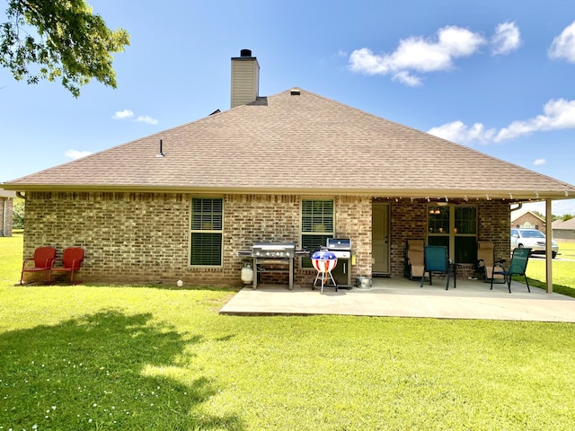 1113 Chesterfield Dr, Webb City, MO 64870 - rear view of property with brick siding, a chimney, a lawn, a patio area, and a shingled roof