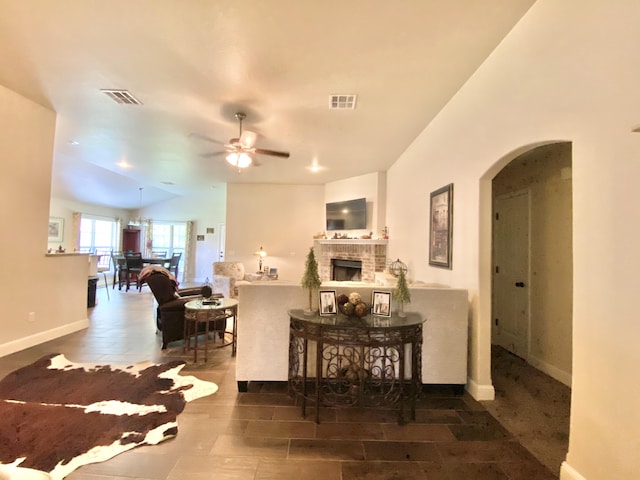 1113 Chesterfield Dr, Webb City, MO 64870 - living room with arched walkways, ceiling fan, and a brick fireplace