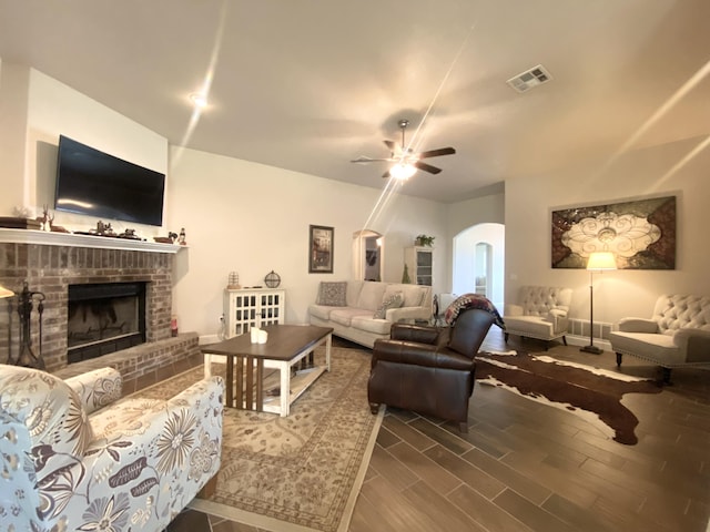 1113 Chesterfield Dr, Webb City, MO 64870 - living room featuring arched walkways, ceiling fan, a brick fireplace, and wood finished floors