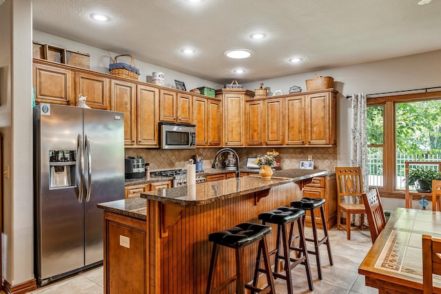 2419 W Deerbrooke Trl, Ozark, MO 65721 - kitchen with appliances with stainless steel finishes, brown cabinets, light tile patterned floors, and recessed lighting