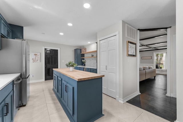 2311 S Golden Ave, Springfield, MO 65807 - kitchen featuring wooden counters, blue cabinetry, recessed lighting, a kitchen island, and freestanding refrigerator