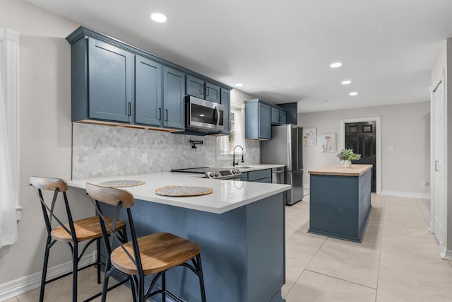 2311 S Golden Ave, Springfield, MO 65807 - kitchen featuring stainless steel appliances, tasteful backsplash, a peninsula, recessed lighting, and a breakfast bar
